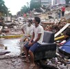 Residentes que ayudan en las labores de rescate se sientan entre escombros que dejaron los terremotos en La Guaira, Venezuela, el 30 de junio de 2026.