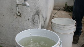 Llave con un chorro de agua en bote de color blanco