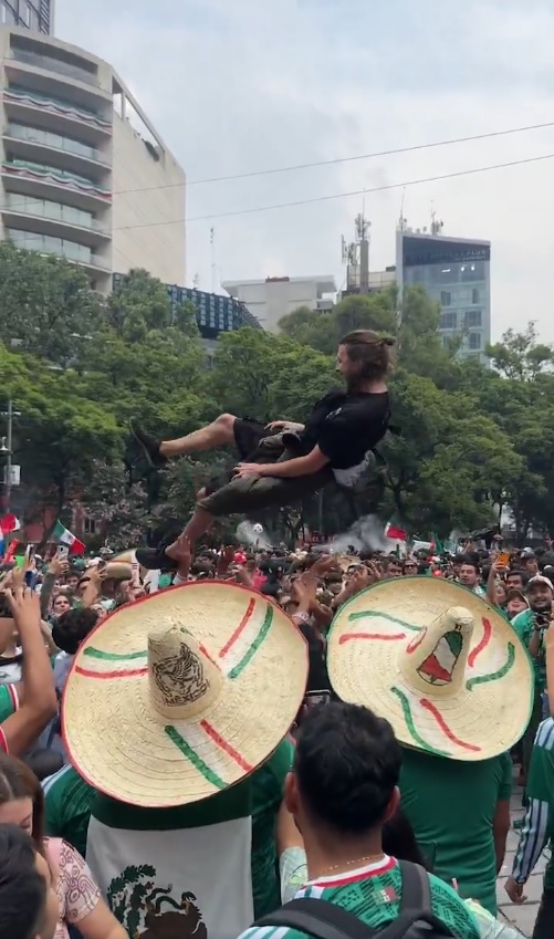 Hombre volando por los aires tras ser arrojado por aficionados mexicanos.