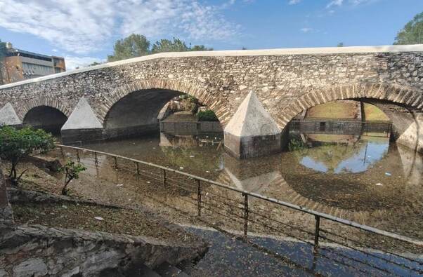 puente de analco con agua y basura de inundaciones