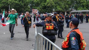 Personal de seguridad revisa a los aficionados en los accesos a Paseo de la Reforma para las pantallas gigantes.