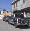 Se observa una patrulla afuera de una casa que tiene graffitis.