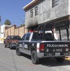 Se observa una patrulla afuera de una casa que tiene graffitis.