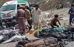 Rescatistas y voluntarios cubren cuerpos después de que un autobús de pasajeros atestado cayó a un barranco, en Dana Sar, en el suroeste de Pakistán