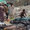 Rescatistas y voluntarios cubren cuerpos después de que un autobús de pasajeros atestado cayó a un barranco, en Dana Sar, en el suroeste de Pakistán