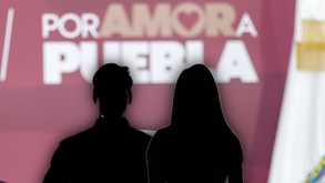 Silueta de un hombre y una mujer junto a un logo del Gobierno de Puebla.