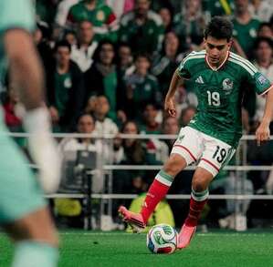 Gilberto Mora jugando fútbol en la cancha con el uniforme de la selección mexicana