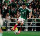 Gilberto Mora jugando fútbol en la cancha con el uniforme de la selección mexicana