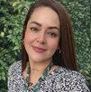 Periodista Roxana Guzmán sonriendo para una fotografía en un campo.