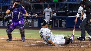 Jugador de Sultanes de Monterrey haciendo una barrida ante uno de Dorados.