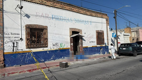 Se observa un cuerpo tendido en la banqueta afuera de un establecimiento con letras que dicen Bar Piedras Negras 1.
