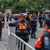 Personal de seguridad revisa a los aficionados en los accesos a Paseo de la Reforma para las pantallas gigantes.