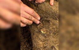Un arqueólogo muestra dos anillos con huesos humanos durante una excavación en el sitio arqueológico de Don Yai Thong, en la provincia de Phetchaburi, Tailandia