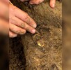 Un arqueólogo muestra dos anillos con huesos humanos durante una excavación en el sitio arqueológico de Don Yai Thong, en la provincia de Phetchaburi, Tailandia