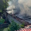 Casa con el techo de teja completamente destruido y emanando humo tras un incendio por explosión de pirotecnia