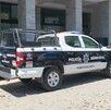 Patrulla de la Policía de Puerto Vallarta estacionada al exterior de un edificio de departamentos con autos y un motociclista alrededor