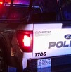 Vista de la parte trasera de una patrulla de la Policía de Tlaquepaque con la sirena encendida durante la noche con lluvia
