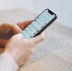 Un teléfono celular con una app de mensajería mientras lo sostiene un par de manos