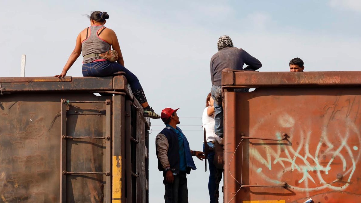 Migrantes arriba de tren en el paso a destino migratorio