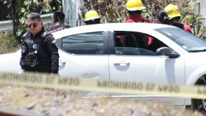 Choche con cintas de prohibido el paso y alrededor policías