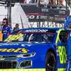 Rubén García Jr. con los brazos cruzados frente a su automóvil 88 en una competencia NASCAR