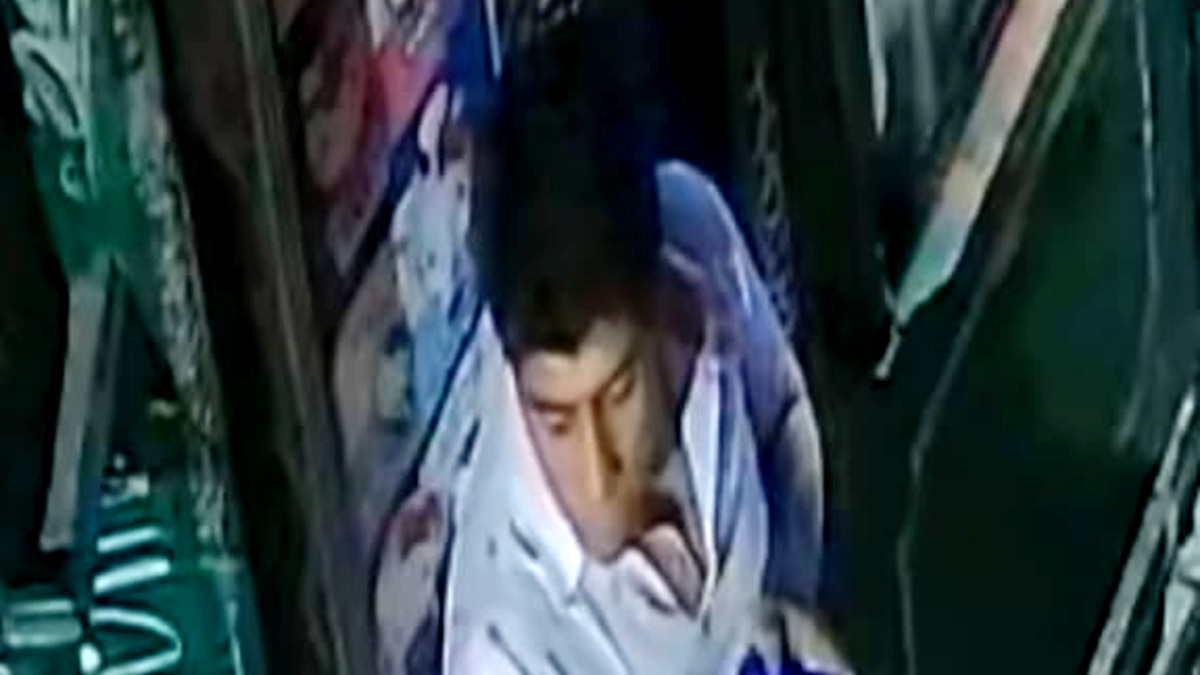 Hombre parado afuera de un puesto de periódico en el centro de Puebla.