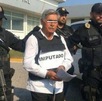 un hombre detenido custodiado por policías