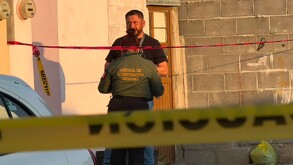 Se observa a un hombre con uniforme y una cinta amarilla de precaución.
