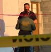 Se observa a un hombre con uniforme y una cinta amarilla de precaución.