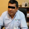 Se observa a un hombre con camisa azul celeste y los ojos tapados con cintilla negra.