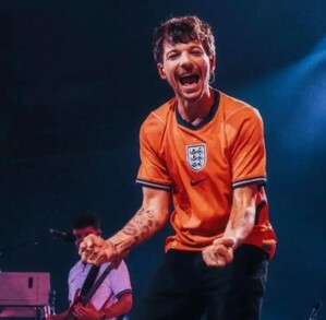 Fotografía de Louis Tomlinson con playera de la Selección de Inglaterra en concierto