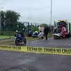 Vecinos y paramédicos de la Cruz Verde y la Cruz Roja con ambulancias dentro de un área acordonada por la policía al lado de un vaso regulador