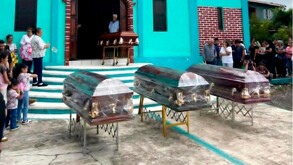 Tres féretros afuera de una iglesia de Veracruz durante una misa de despedida.