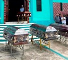 Tres féretros afuera de una iglesia de Veracruz durante una misa de despedida.