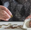Persona adulta mayor fotografiada con monedas en las manos