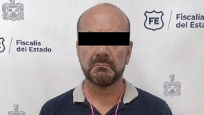 Se observa a un hombre con ojos tapados, con playera y pantalón de mezclilla.