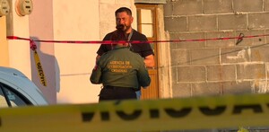 Se observa a un hombre con uniforme y una cinta amarilla de precaución.