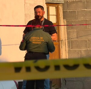 Se observa a un hombre con uniforme y una cinta amarilla de precaución.