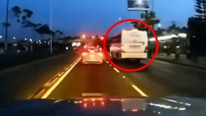 Camión de transporte de personal color blanco encerrado en un círculo rojo rebasando a un auto en una carretera de Zapopan