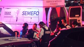 Personal del Servicio Médico Forense en una escena del crimen durante la noche.