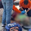 Paramédicos bridando atención médica a una paciente tumbada en el suelo con un tanque de oxígeno a un lado