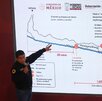 un hombre apuntando a una pantalla con un diagrama