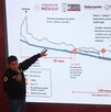 un hombre apuntando a una pantalla con un diagrama