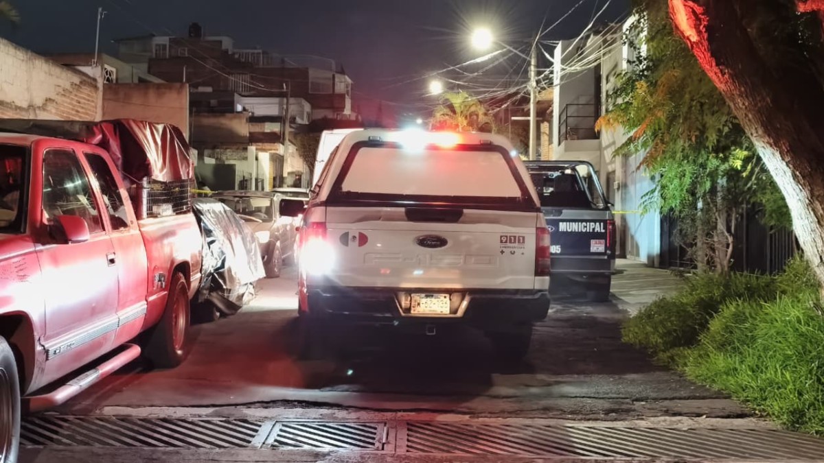 Vista de la parte trasera de una camioneta blanca de las autoridades de Zapopan con una patrulla delante y cerca de un área acordonada por la policía