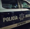 Vista del costado de una patrulla de la Policía de Zapopan estacionada en medio de una calle con casas a los costados