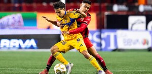 Diego Laínez y Jesús Vega peleando un balón en el partido de Tigres vs Tijuana.