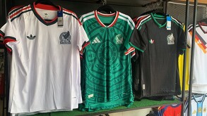 Tres playeras de la Selección Mexicana en colores blanco, verde y negro colgadas dentro de una tienda