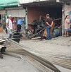 Se observan llantas y una fachada; hay varias personas paradas en la vía pública.
