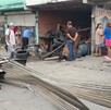 Se observan llantas y una fachada; hay varias personas paradas en la vía pública.