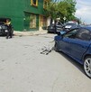 Se observan unos carros y unas personas de pie en la víc pública.